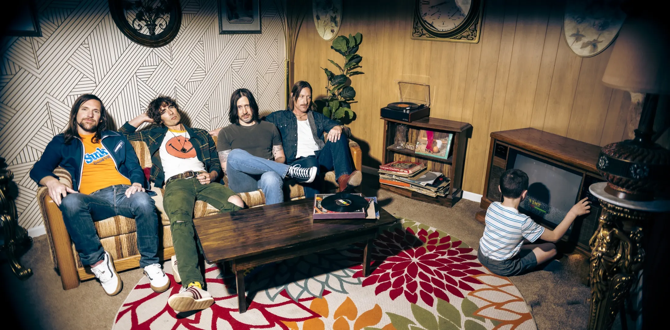 The All-American Rejects on a couch in a seventies living room